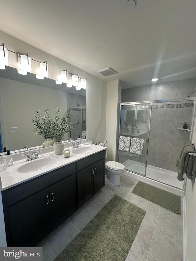 bathroom featuring vanity, toilet, an enclosed shower, and tile patterned flooring