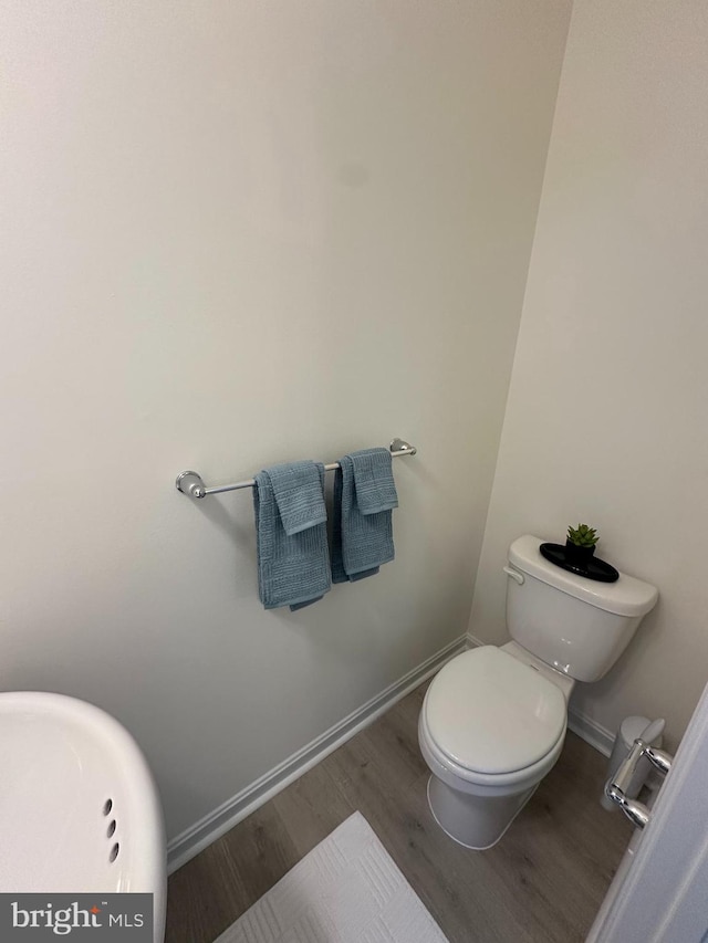 bathroom featuring hardwood / wood-style flooring and toilet