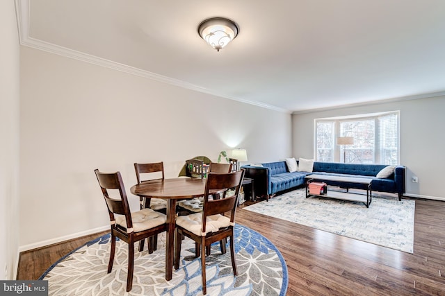 dining space featuring wood-type flooring and crown molding