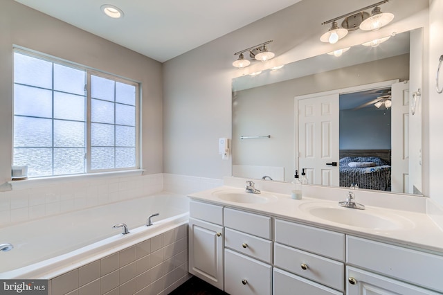 bathroom featuring vanity and tiled bath