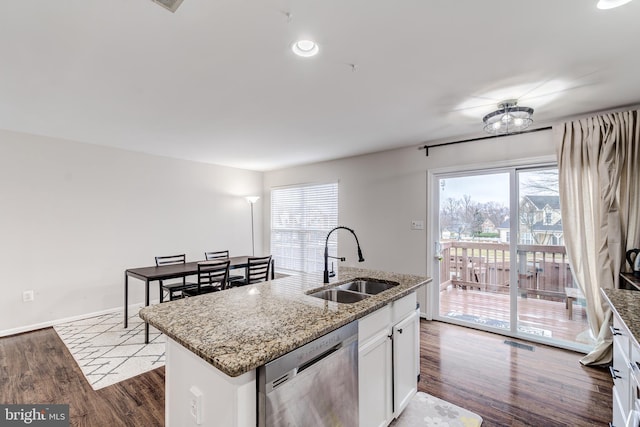 kitchen with white cabinetry, an island with sink, sink, stainless steel dishwasher, and light stone countertops