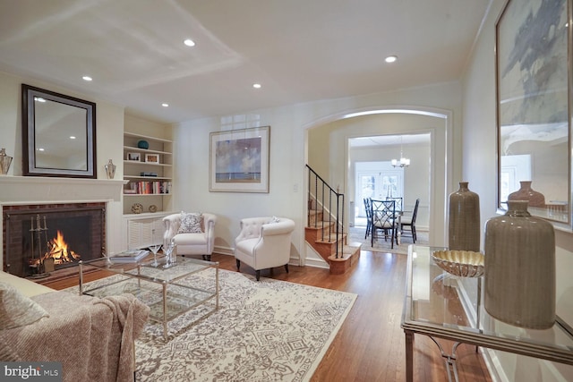 living room featuring hardwood / wood-style flooring, a fireplace, and built in features