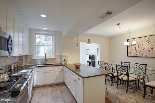 kitchen with white cabinetry, decorative light fixtures, stainless steel appliances, and kitchen peninsula