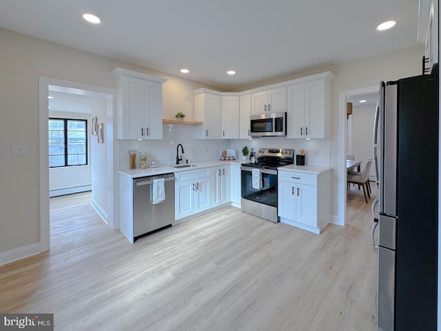 kitchen with appliances with stainless steel finishes, sink, and white cabinets