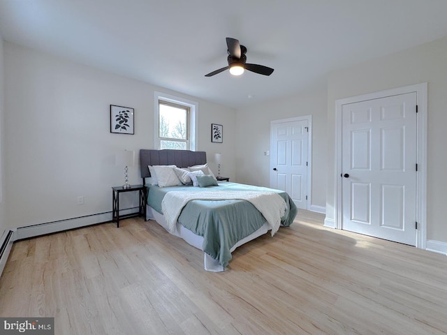 bedroom featuring a baseboard radiator, ceiling fan, and light wood-type flooring