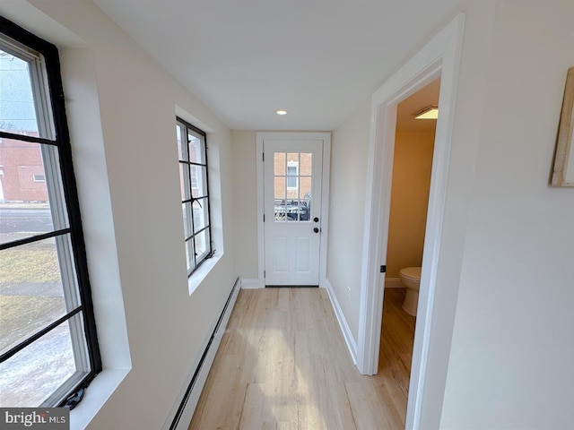 doorway to outside with a baseboard radiator and light hardwood / wood-style floors