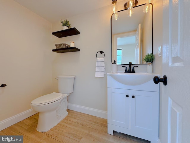 bathroom featuring vanity, hardwood / wood-style flooring, and toilet