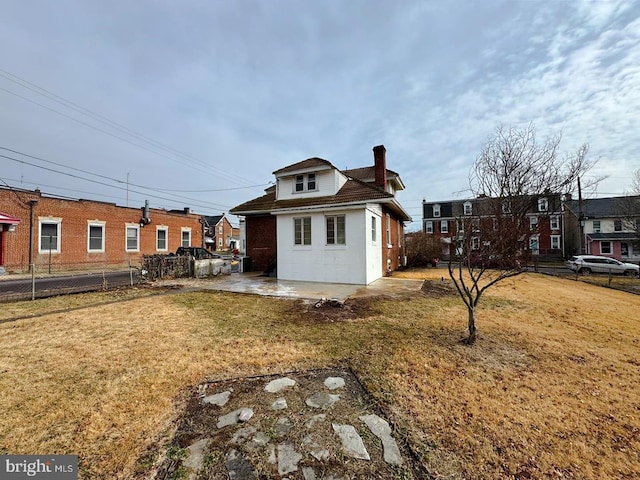 rear view of property with a patio and a lawn