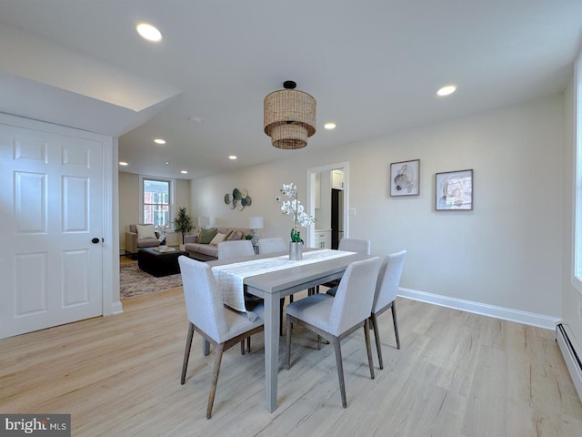 dining space featuring a baseboard heating unit and light hardwood / wood-style floors