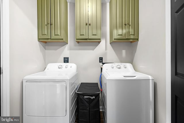 washroom featuring cabinets and washing machine and dryer