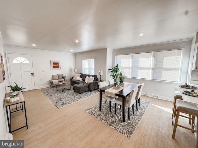 dining room featuring crown molding and light hardwood / wood-style floors