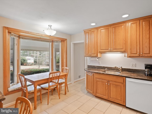 kitchen featuring sink, dark stone countertops, and white dishwasher