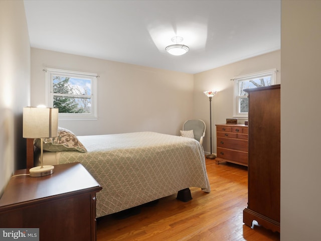 bedroom with multiple windows and light hardwood / wood-style floors