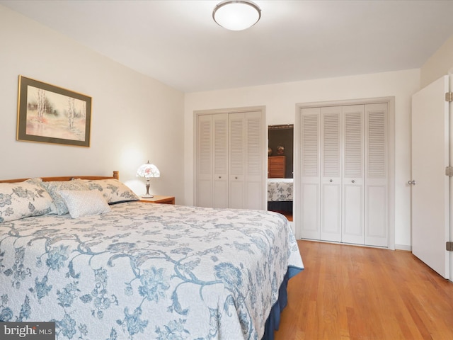 bedroom featuring multiple closets and light hardwood / wood-style floors