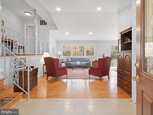 living room with high vaulted ceiling and light hardwood / wood-style flooring