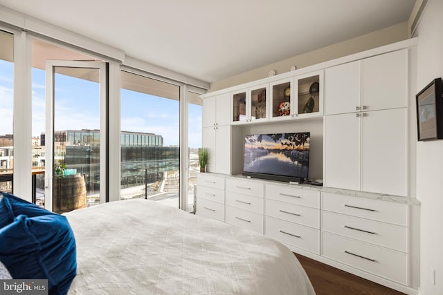 bedroom featuring floor to ceiling windows, dark hardwood / wood-style floors, and access to outside