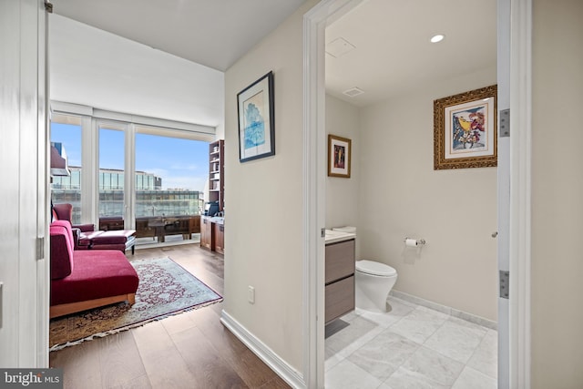 bathroom featuring vanity, hardwood / wood-style floors, and toilet