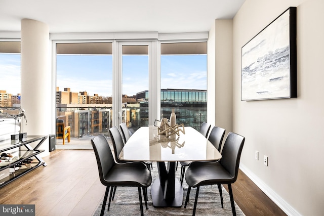 dining space featuring expansive windows and hardwood / wood-style floors