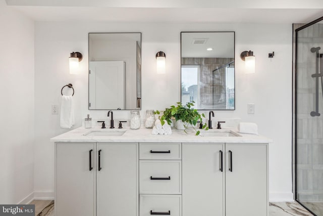 bathroom featuring a shower with door and vanity