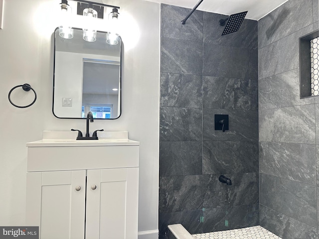 bathroom featuring tiled shower and vanity