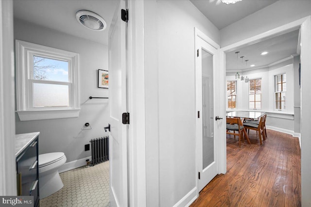 bathroom with radiator, plenty of natural light, hardwood / wood-style floors, and toilet