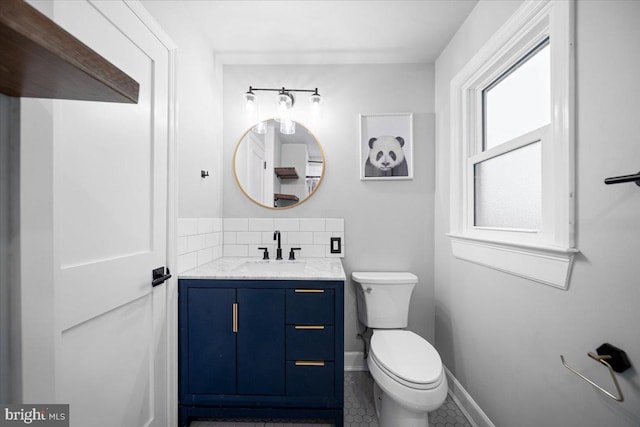 bathroom with vanity, tasteful backsplash, and toilet