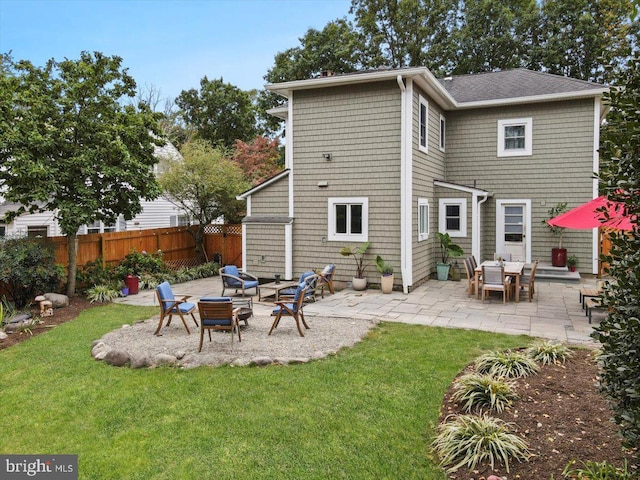 back of house featuring a patio area, a lawn, and an outdoor fire pit