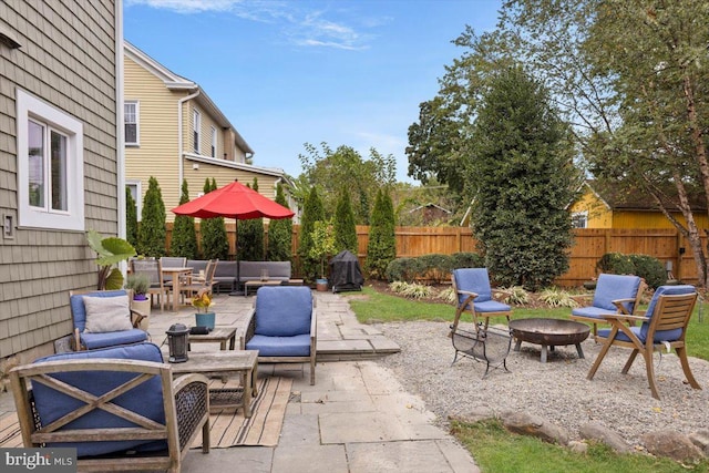 view of patio with area for grilling and an outdoor living space with a fire pit