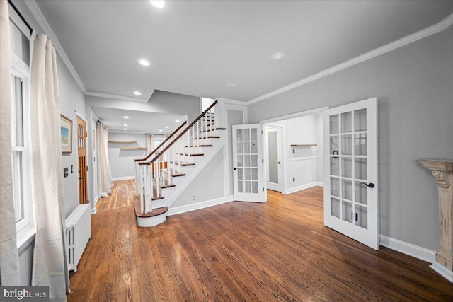 interior space with hardwood / wood-style flooring, radiator heating unit, ornamental molding, and french doors