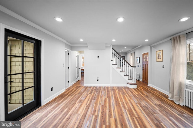 entryway featuring hardwood / wood-style flooring, radiator heating unit, and crown molding