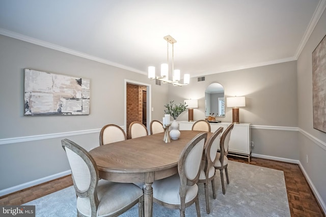 dining area featuring ornamental molding, parquet flooring, and a chandelier