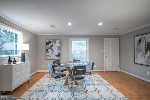 dining room featuring crown molding and light parquet floors