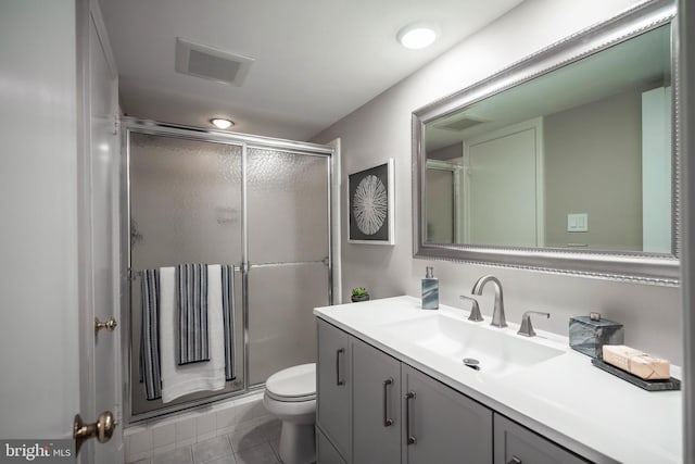 bathroom featuring vanity, tile patterned floors, toilet, and walk in shower