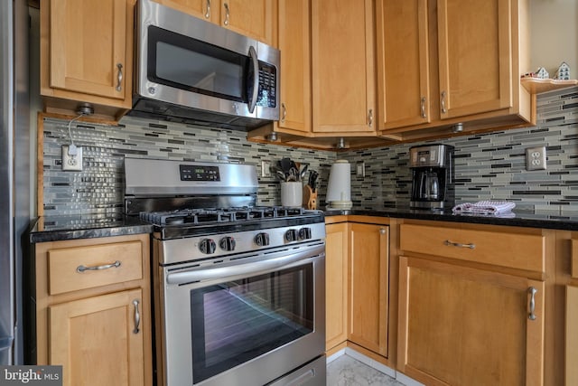 kitchen with tasteful backsplash, stainless steel appliances, and dark stone counters