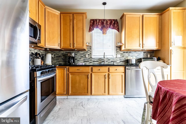 kitchen featuring pendant lighting, sink, tasteful backsplash, and appliances with stainless steel finishes