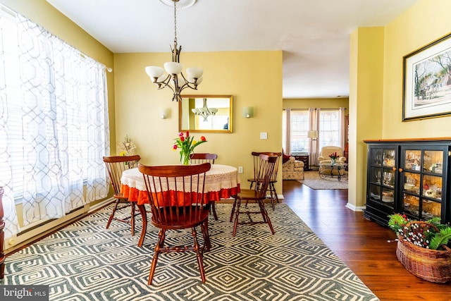 dining space featuring dark hardwood / wood-style floors and a chandelier