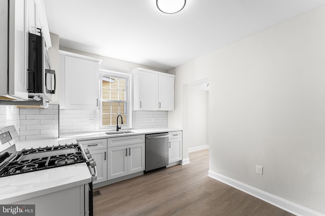 kitchen featuring light stone countertops, appliances with stainless steel finishes, sink, and white cabinets