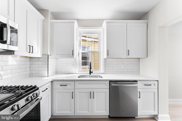 kitchen with white cabinetry, sink, and stainless steel appliances