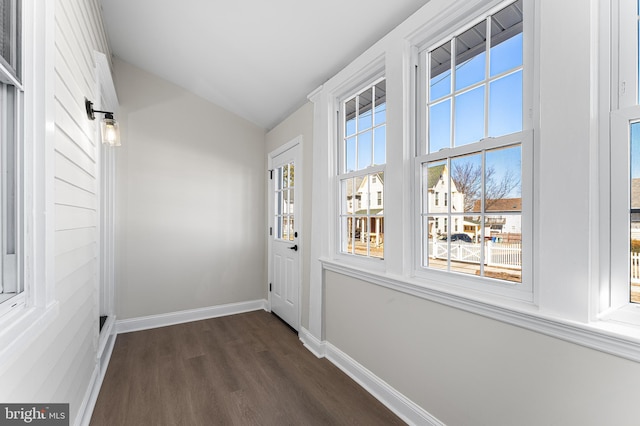 doorway with dark hardwood / wood-style floors and vaulted ceiling