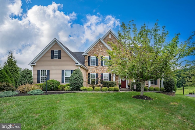 view of front of home with stone siding, a front lawn, and brick siding