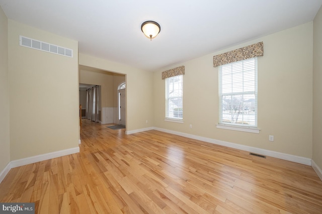 unfurnished room with light wood-style floors, baseboards, and visible vents