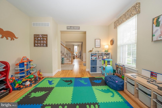 rec room featuring light wood finished floors, baseboards, and visible vents