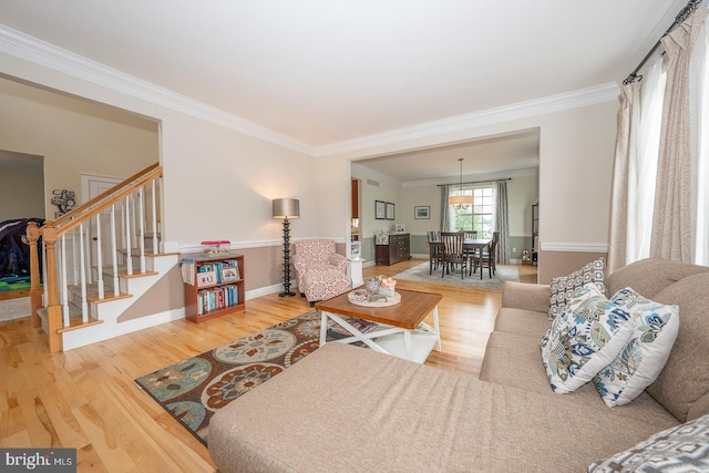 living room featuring stairs, ornamental molding, and wood finished floors