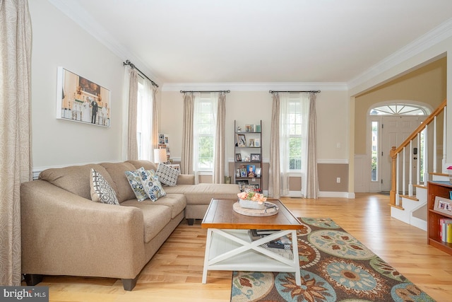 living room featuring ornamental molding, stairway, and light wood finished floors