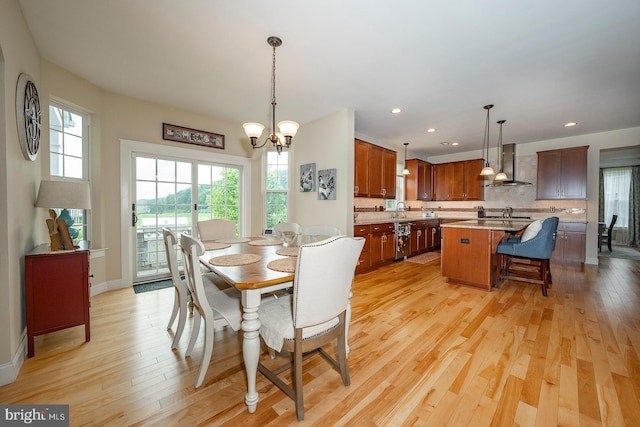 dining space with light wood-style flooring, a notable chandelier, and recessed lighting