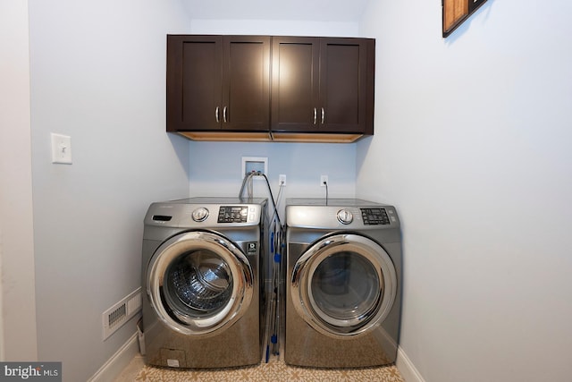 laundry area featuring cabinet space, baseboards, and separate washer and dryer