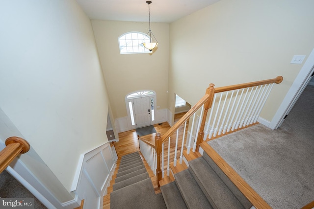 foyer entrance with baseboards, stairway, a high ceiling, and wood finished floors