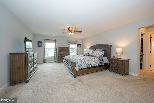 bedroom featuring baseboards, ceiling fan, and light colored carpet