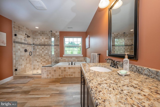 full bathroom featuring a garden tub, visible vents, vanity, a shower stall, and wood tiled floor