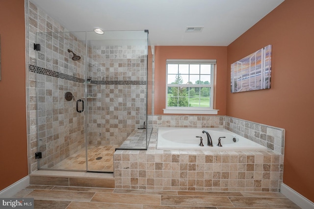 bathroom featuring a garden tub, baseboards, visible vents, and a stall shower